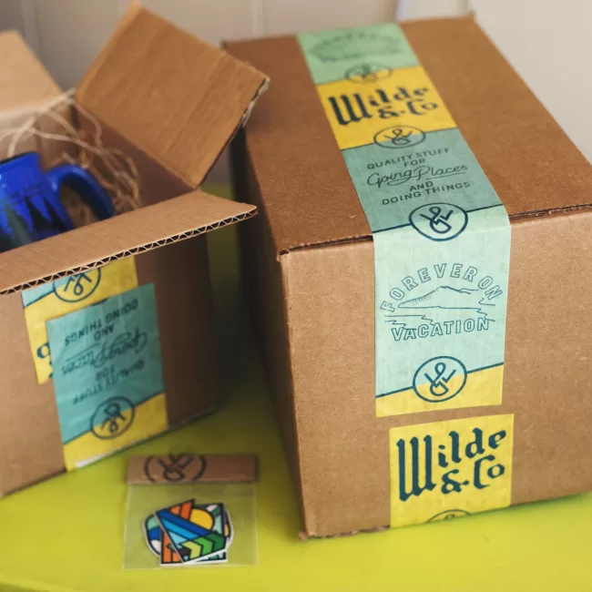Cajas de cartón , una de las cuales está abierta mostrando una taza azul en su interior protegida con relleno para un empaque seguro.